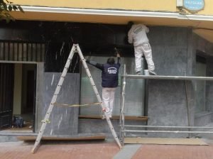 Dos trabajadores de Pavimentos Muriel realizando abrillantado de mármol en fachada